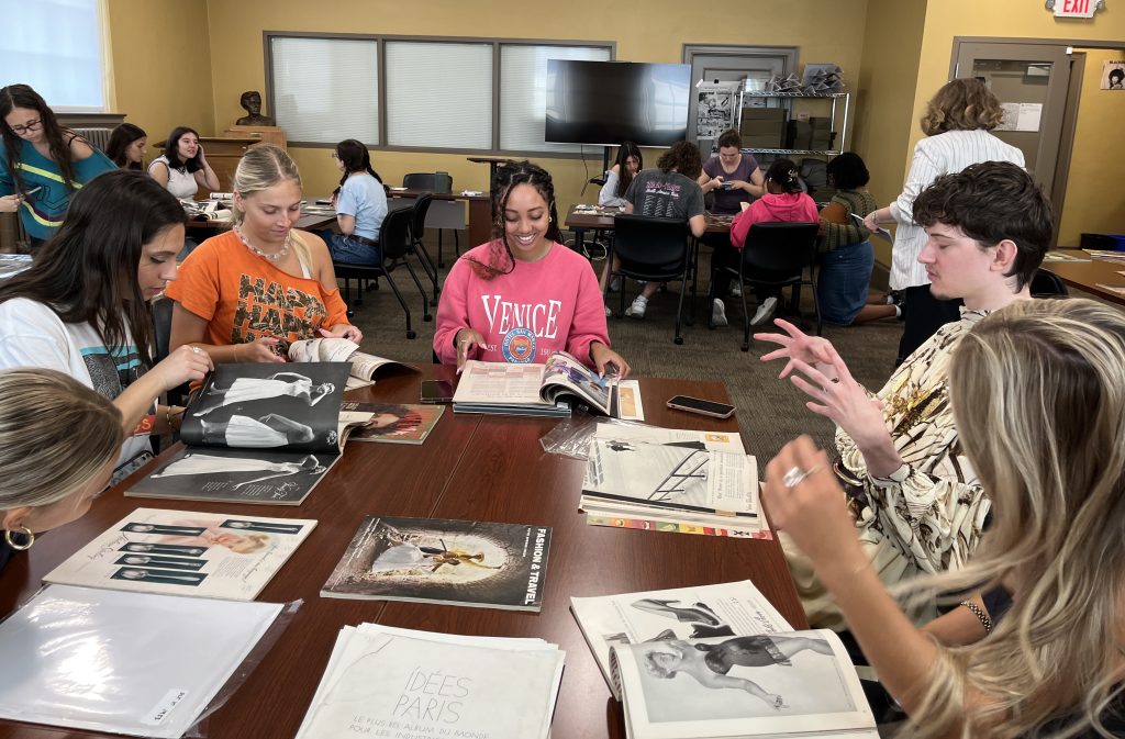 Students view historical fashion magazines in Ellis Library Special Collections.